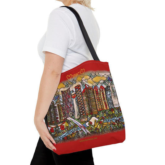 red tote bag on womans shoulder. has artwork of city of  calgary