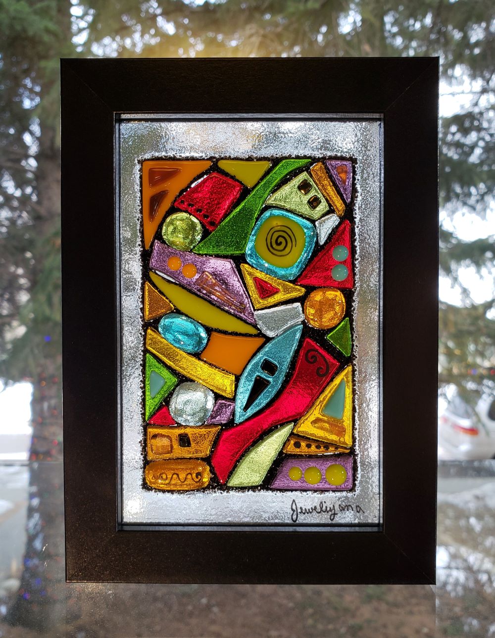 Colorful abstract made of fused glass in black frame