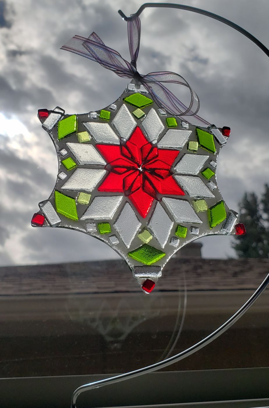 handmade glass snowflake ornament shown in window