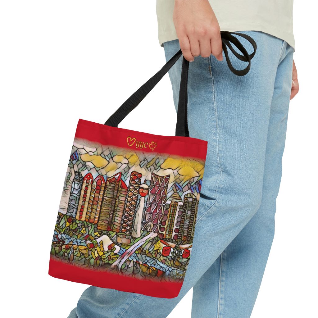 man holding a red tote bag with calgary scene on it 