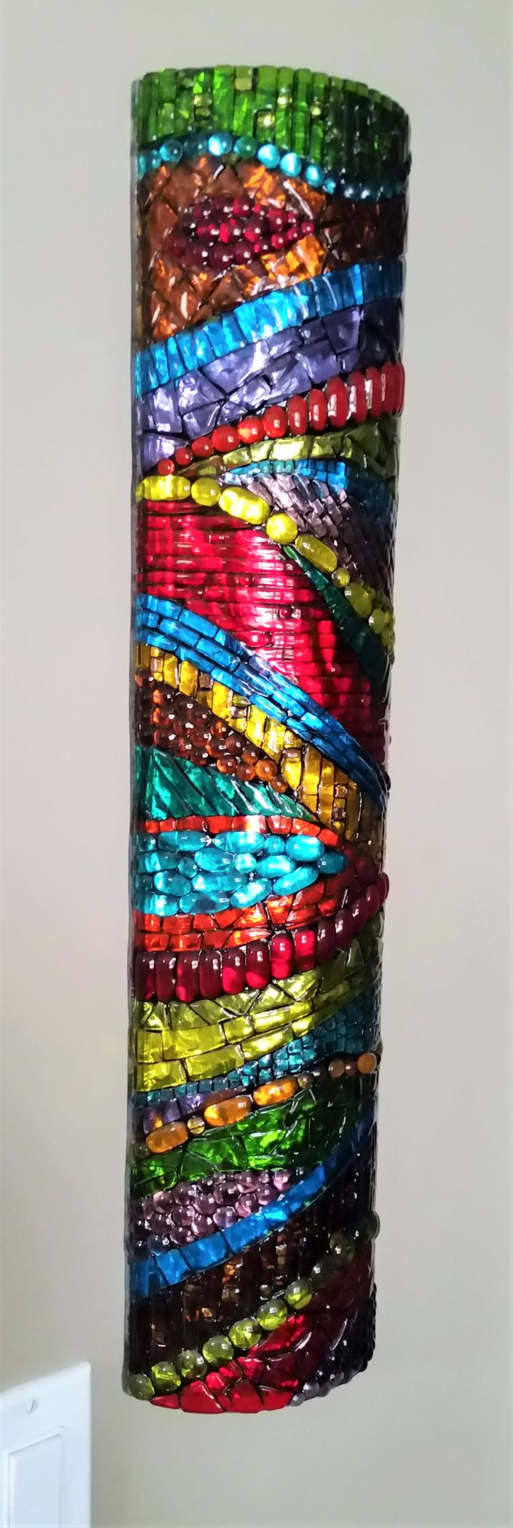 side view of glass art sconce shown on a wall